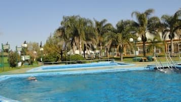 Una piscina al aire libre de temporada, sillones reclinables de piscina