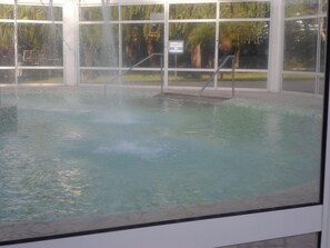 Una piscina al aire libre de temporada, sillones reclinables de piscina