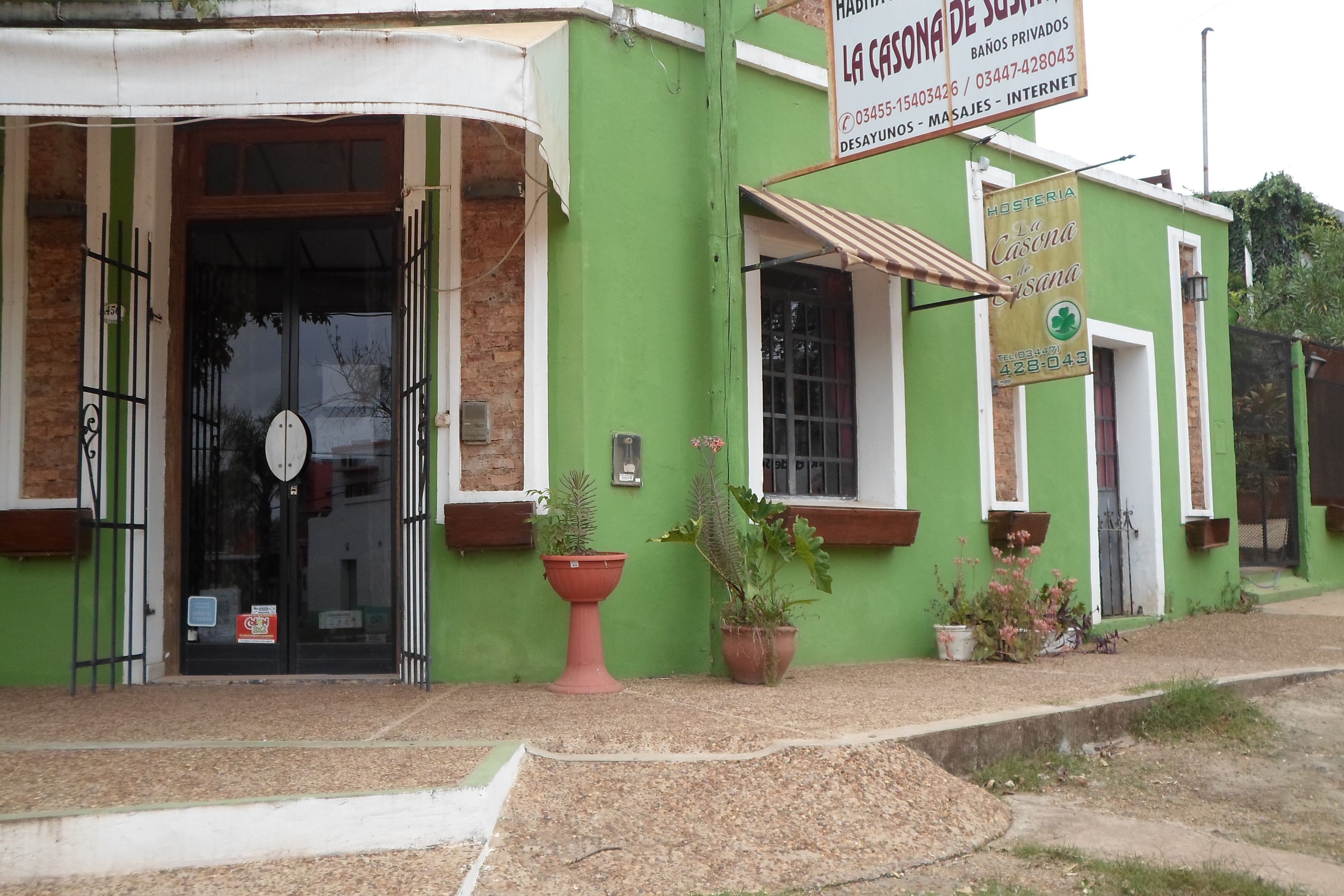 A green building with a sign for 'La Casa de la Casana' and a telephone number.