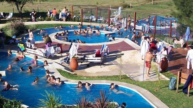 A large outdoor swimming pool with multiple sections, surrounded by lounge chairs and umbrellas. - La Casona de Susana (Colon)