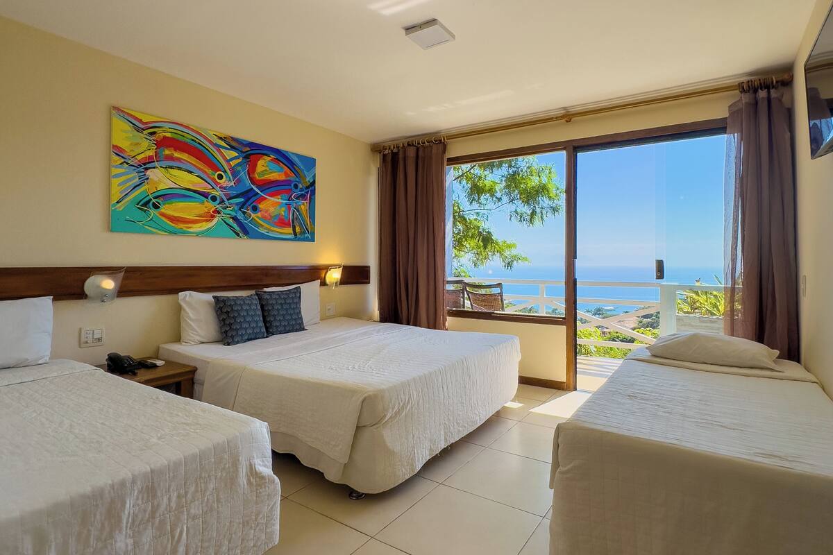 Una habitación de hotel con dos camas, un cuadro en la pared y vistas al mar.