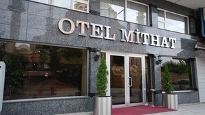 A modern hotel entrance with the name "OTEL MITHAT" prominently displayed.