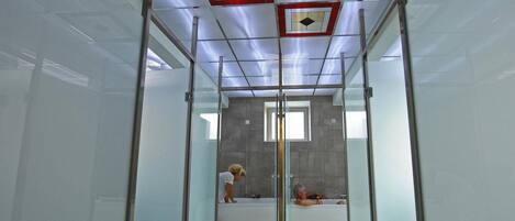 A modern bathroom with a glass enclosure, a shower area, and a bathtub.