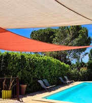 Una piscina al aire libre, sillones reclinables de piscina