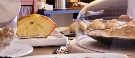 A breakfast buffet with bread, pastries, and nuts.