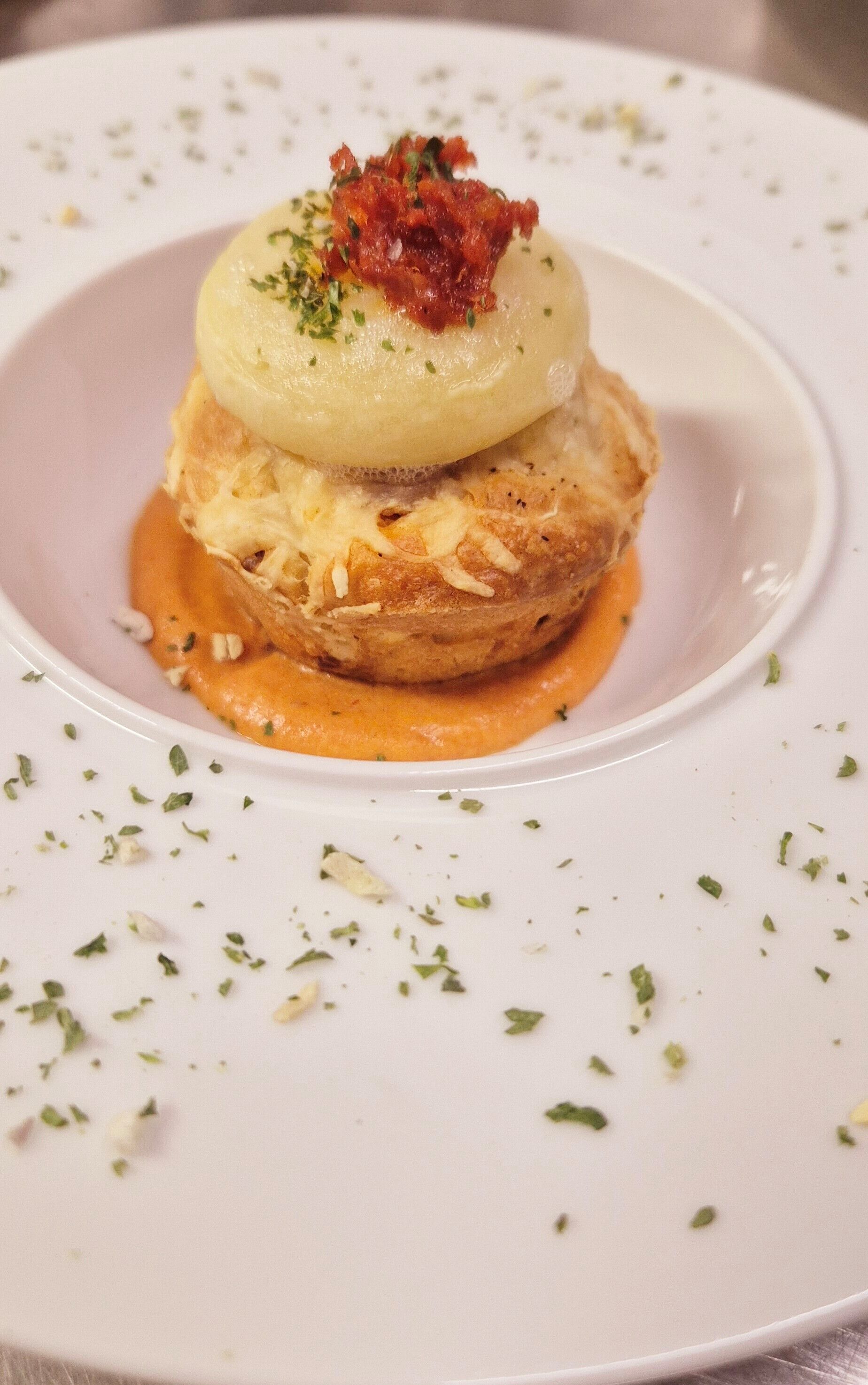 Un plato con salsa cremosa y adornado con hierbas.