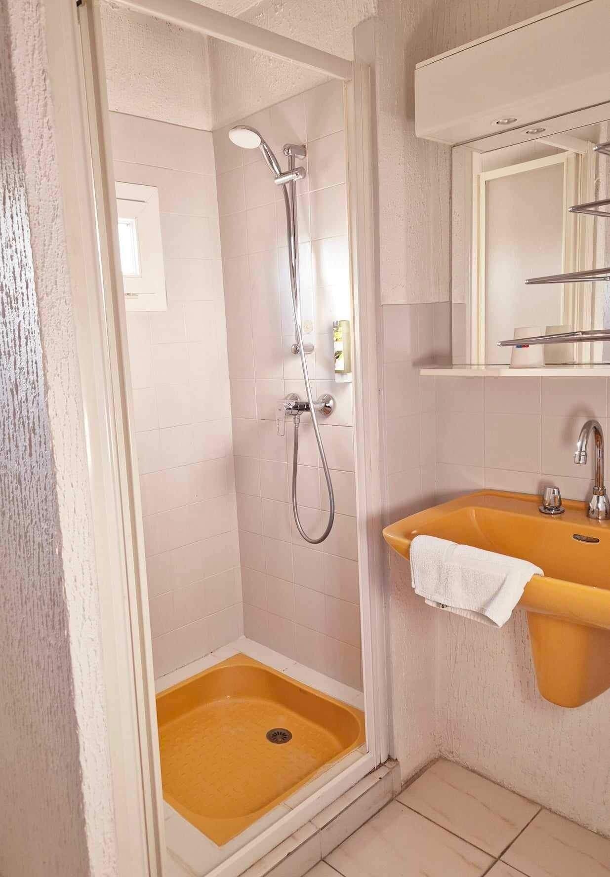 A bathroom with a shower, a sink, and a mirror.