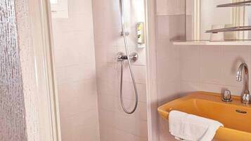 A bathroom with a shower, a sink, and a mirror.
