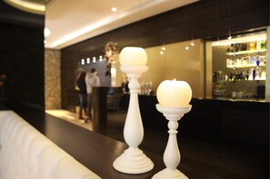 A bar area with a dark counter and a display of bottles. - Els Caçadors (Ribes De Freser)