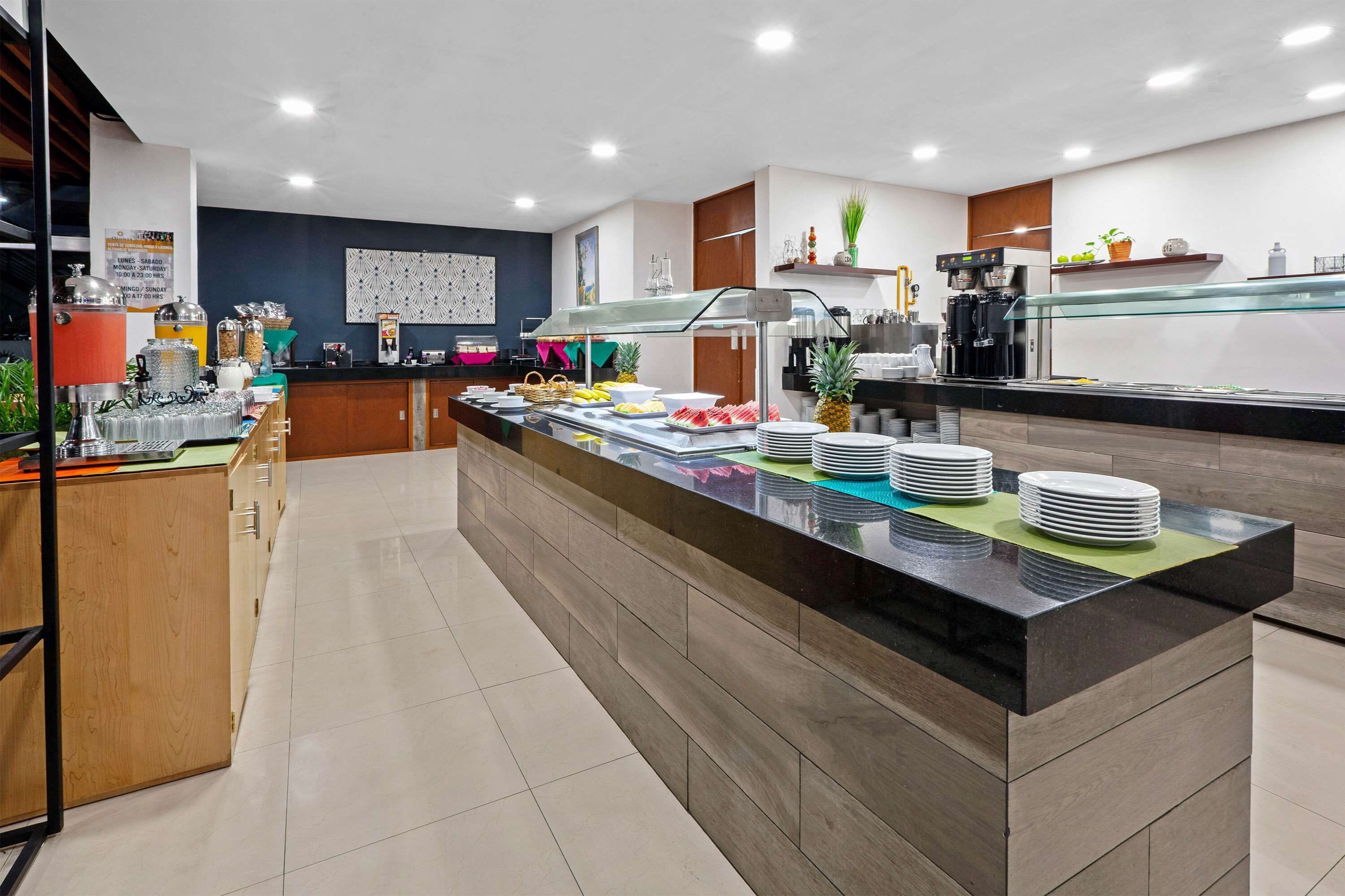 A modern buffet setup with a variety of food items and a coffee machine.