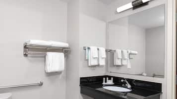 A modern bathroom with a black sink, white toilet, and multiple towel dispensers.