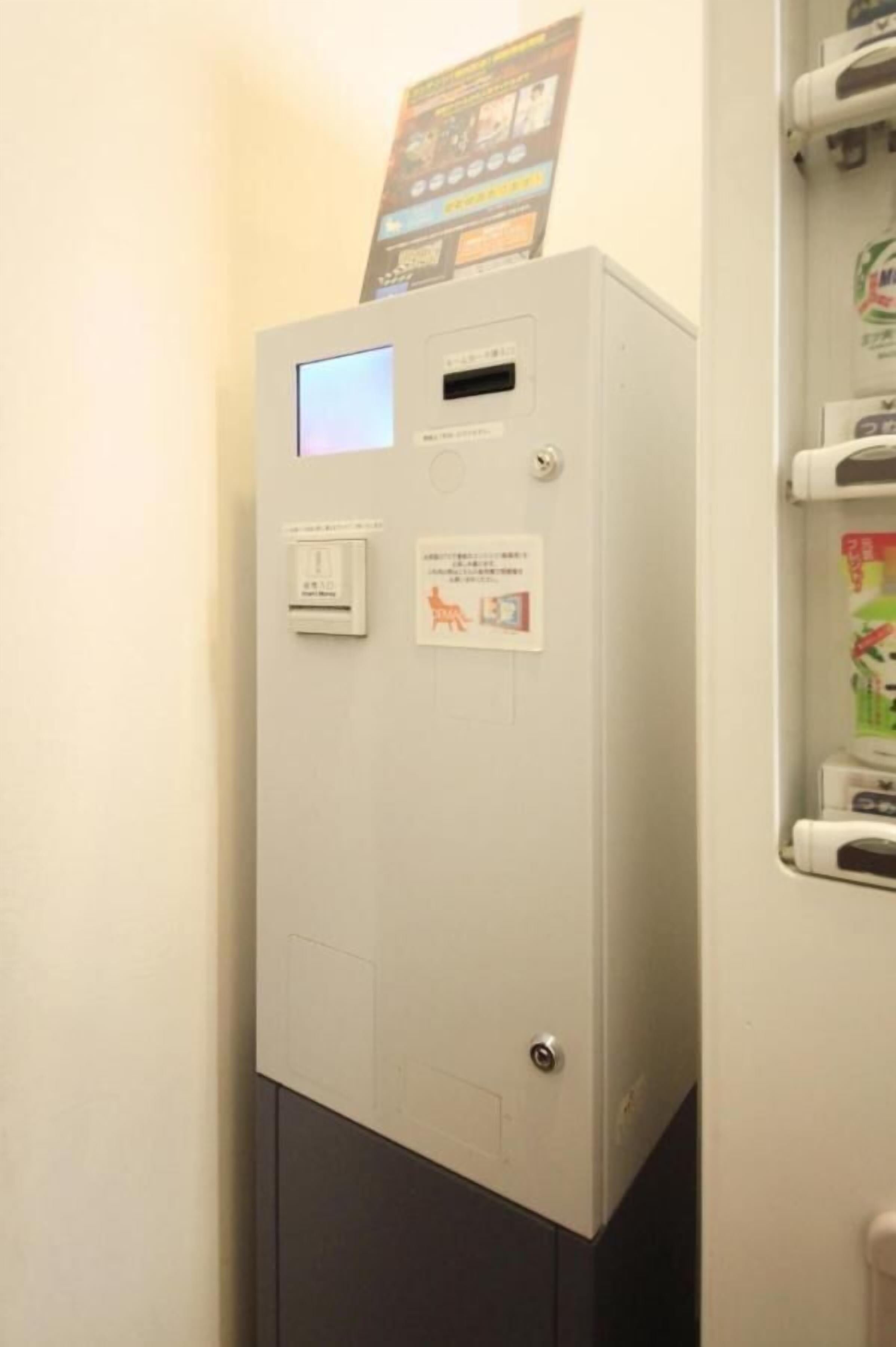 A utility meter with a digital display and a small window, mounted on a wall with a door below it.