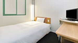 Una habitación de hotel con una cama individual, un escritorio con televisor y una ventana con persianas.