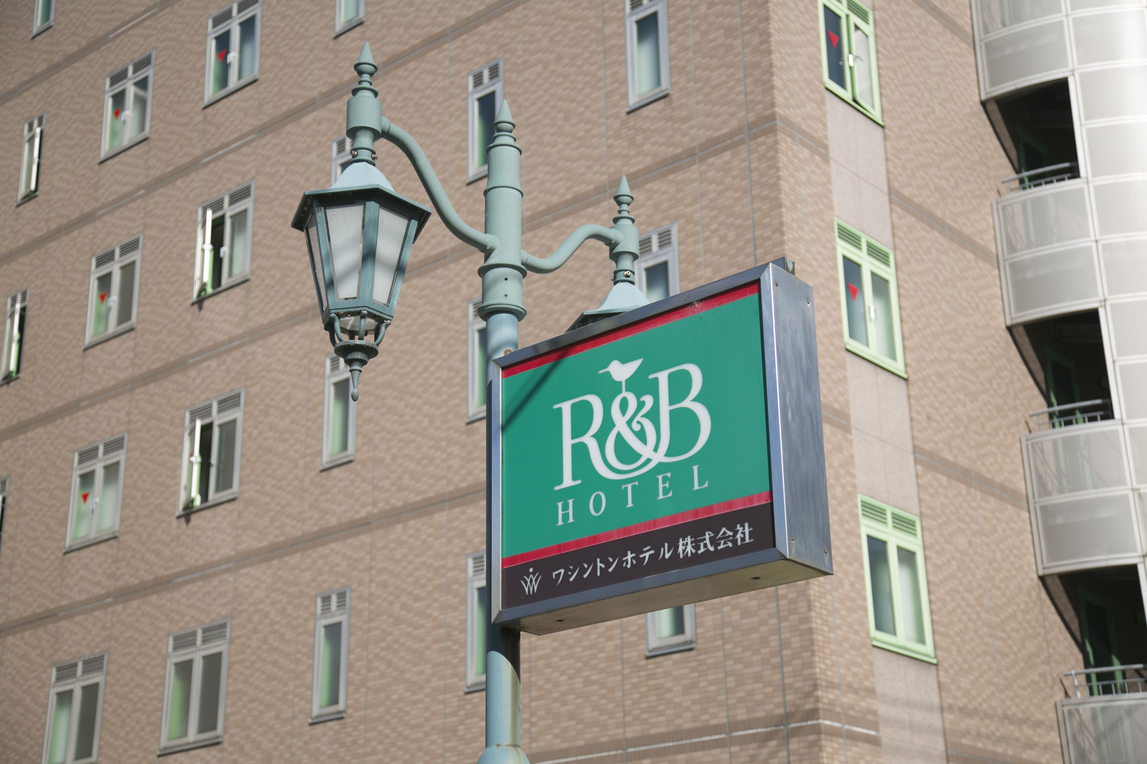 A hotel sign with the name "R&B Hotel" and Japanese text.