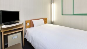 Habitació d'hotel amb llit, televisió sobre un suport de fusta, escriptori i un petit armari.