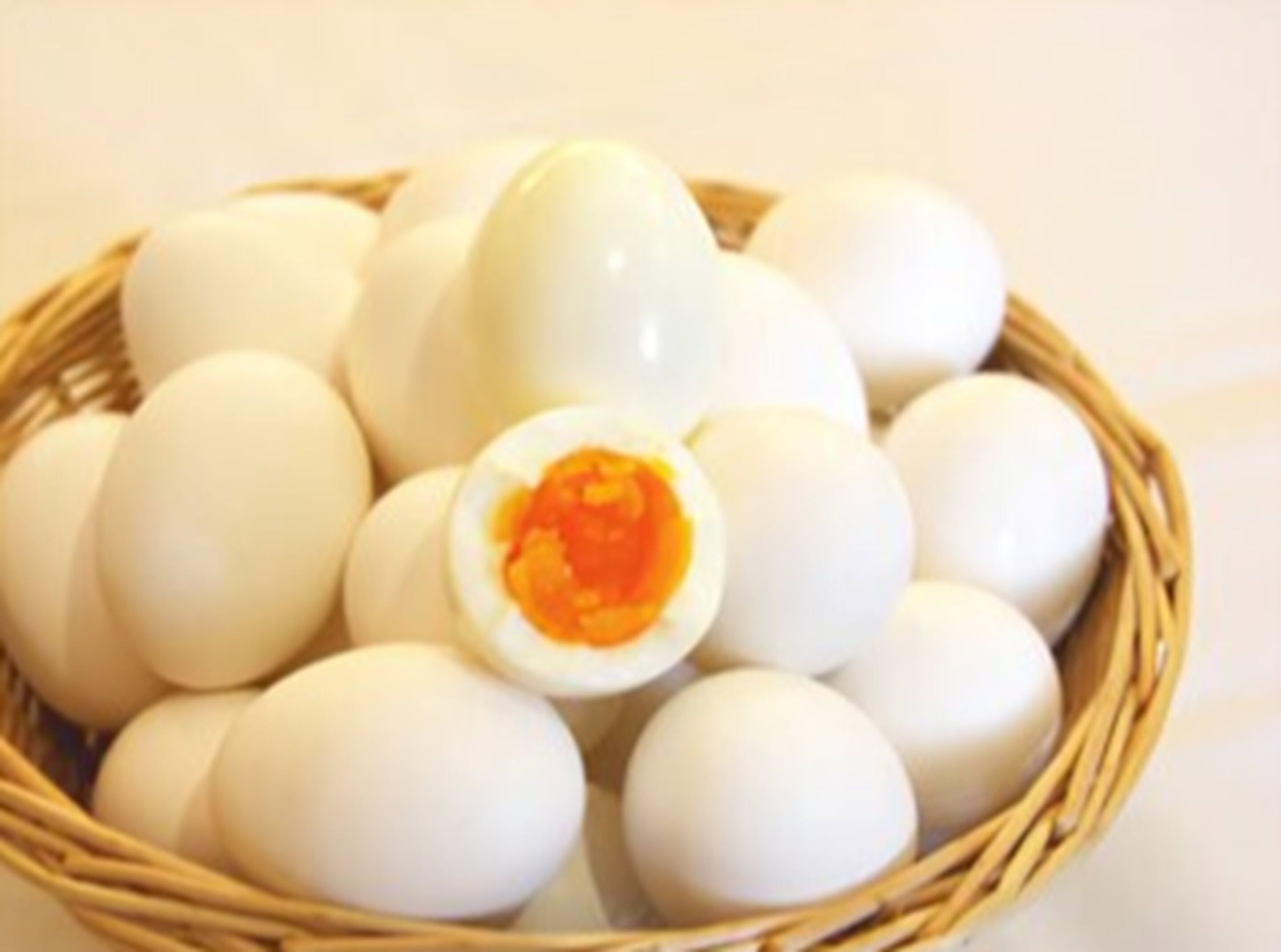 Uma cesta com ovos cozidos, um deles cortado ao meio.
