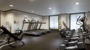 A gym with treadmills, dumbbells, and a water dispenser.