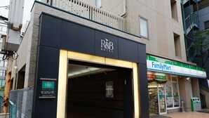 The R&B Hotel entrance with a FamilyMart store adjacent.