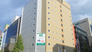 Un hôtel à plusieurs étages, reconnaissable à son grand panneau situé en haut de la façade.