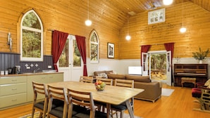 A wooden interior with a dining area, kitchen, and living space. - Bruny Island Escapes and Hotel Bruny (Alonnah)