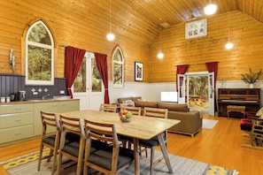 A wooden interior with a dining area, kitchen, and living space. - Bruny Island Escapes and Hotel Bruny (Alonnah)