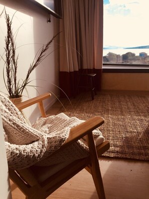 A cozy room with a wooden chair, a woven rug, and a potted plant. - Bruny Island Escapes and Hotel Bruny (Alonnah)