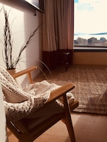 Una habitación acogedora con una silla de madera, un tapiz tejido y una planta en maceta.