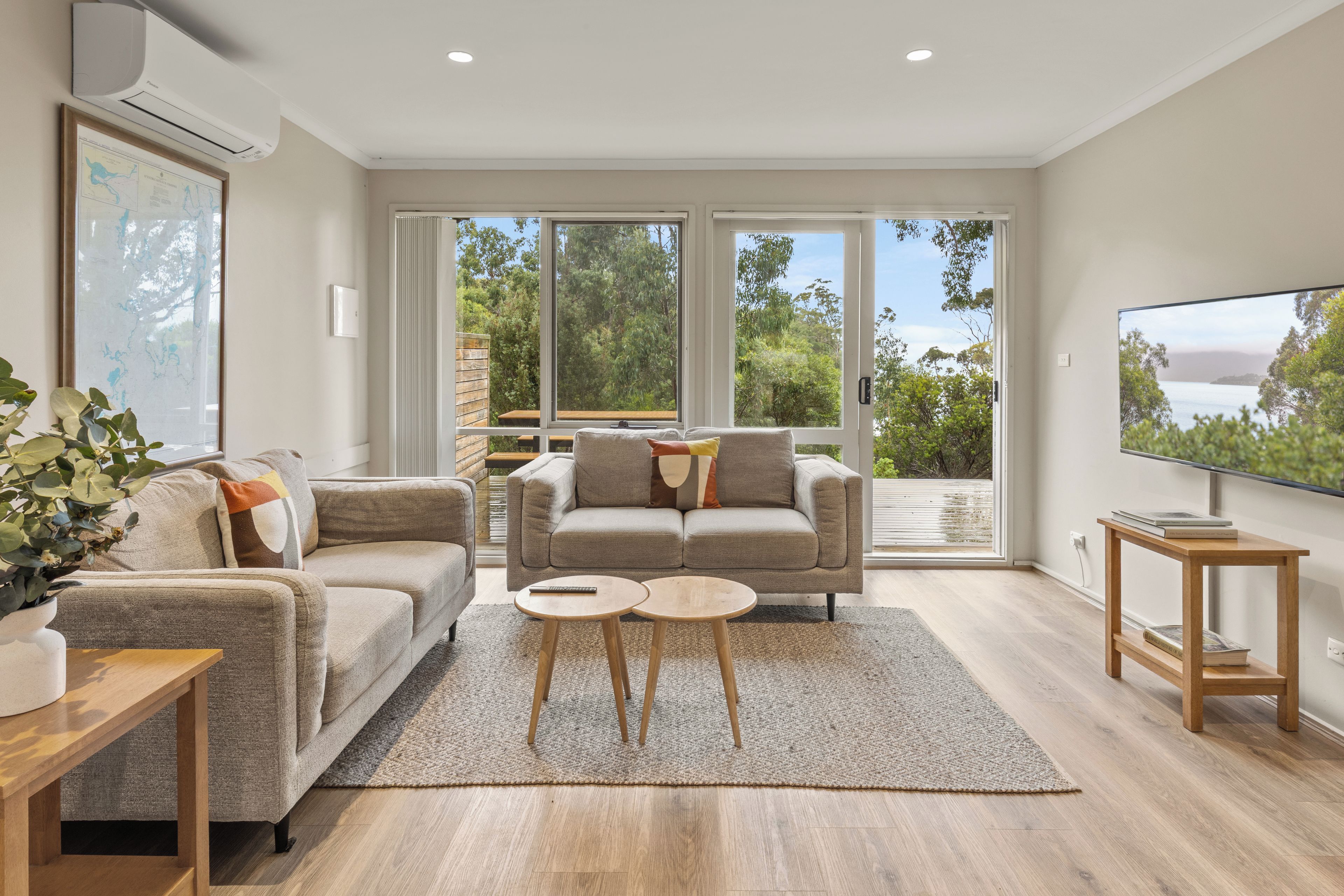 Una sala moderna con un sofá, una mesa de centro y un mueble para televisión.