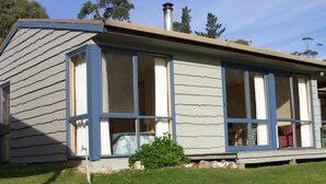 A single-story house with a gabled roof, large windows, and a chimney. - Bruny Island Escapes and Hotel Bruny (Alonnah)