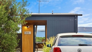 A modern building with a visible room number 'FIVE' and a parked white car. - Bruny Island Escapes and Hotel Bruny (Alonnah)
