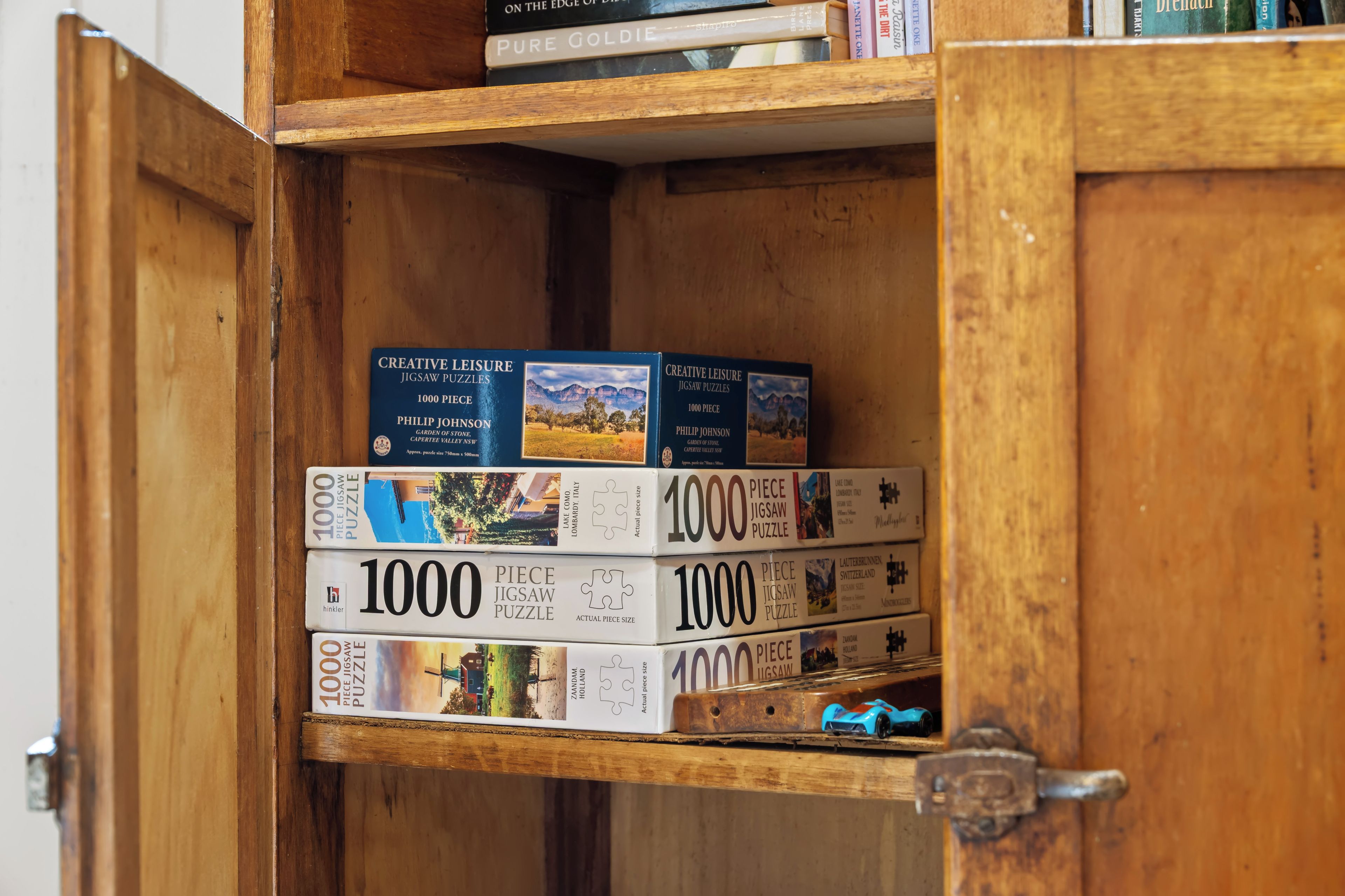 Un mueble de madera con varios juegos de rompecabezas.