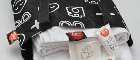 A stack of folded towels with a black and white pattern and Tune Hotels branding.