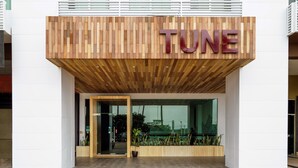 A modern building with a wooden facade and the word "TUNE" prominently displayed. - Tune Hotels - 1 Borneo, Kota Kinabalu (Kota Kinabalu)