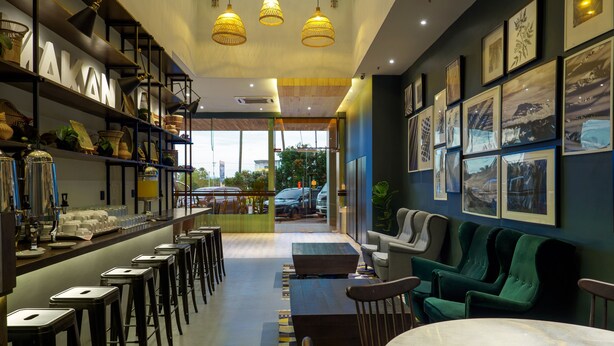 A modern interior with a bar area, seating, and artwork on the walls. - Tune Hotels - 1 Borneo, Kota Kinabalu (Kota Kinabalu)