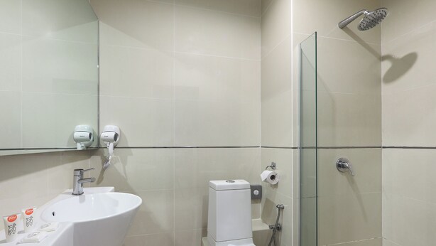 A bathroom with a white sink, toilet, and glass shower enclosure.