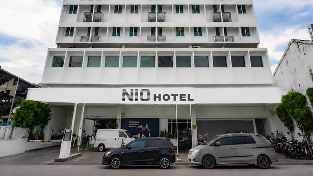A multi-story hotel with balconies, a clear sky, and a sign reading 'NIO HOTEL'. - NIO Hotel (George Town)