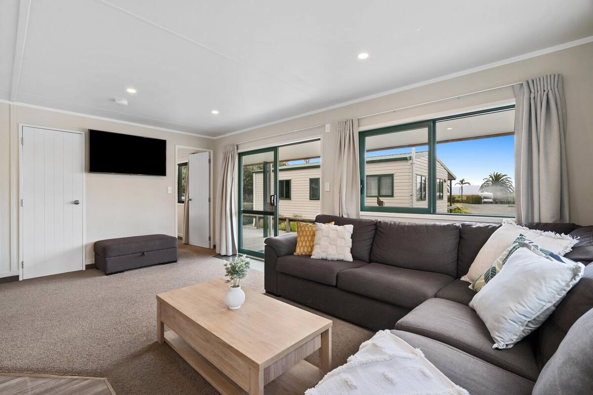A modern living room with a sofa, a coffee table, and a TV.