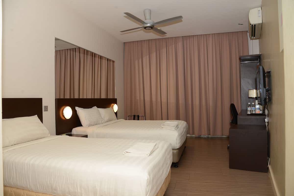 Habitación de hotel con dos camas, ventilador de techo, minibar y un gran ventanal con cortinas.