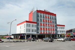 Un hotel de varios pisos con fachada roja y blanca, varios niveles y un llamativo letrero con el número '101' en la parte superior.