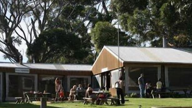 A park with picnic tables and a small wooden shelter.