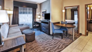 Een hotelkamer met een bank, bureau, stoel en een bed.
