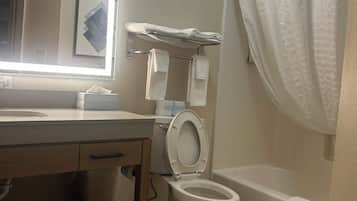 A bathroom with a toilet, sink, mirror, and shower curtain.