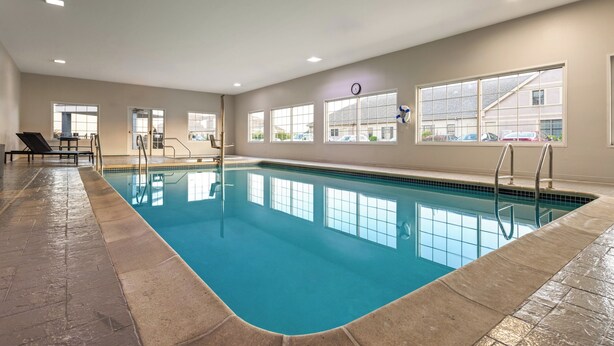 An indoor swimming pool with clear blue water, tiled floor, and windows offering views of the outside. - Candlewood Suites Chambersburg by IHG (Chambersburg)