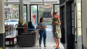 A modern interior with a sofa, dining area, and large windows. - Windbell Villa (Da Nang)