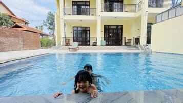 Relax by the rectangular pool surrounded by comfortable outdoor seating areas and the building's large windows.