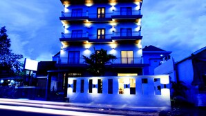 A multi-story hotel with balconies and a well-lit facade. - Heart Language Angkor Hotel - Hostel (Siem Reap)