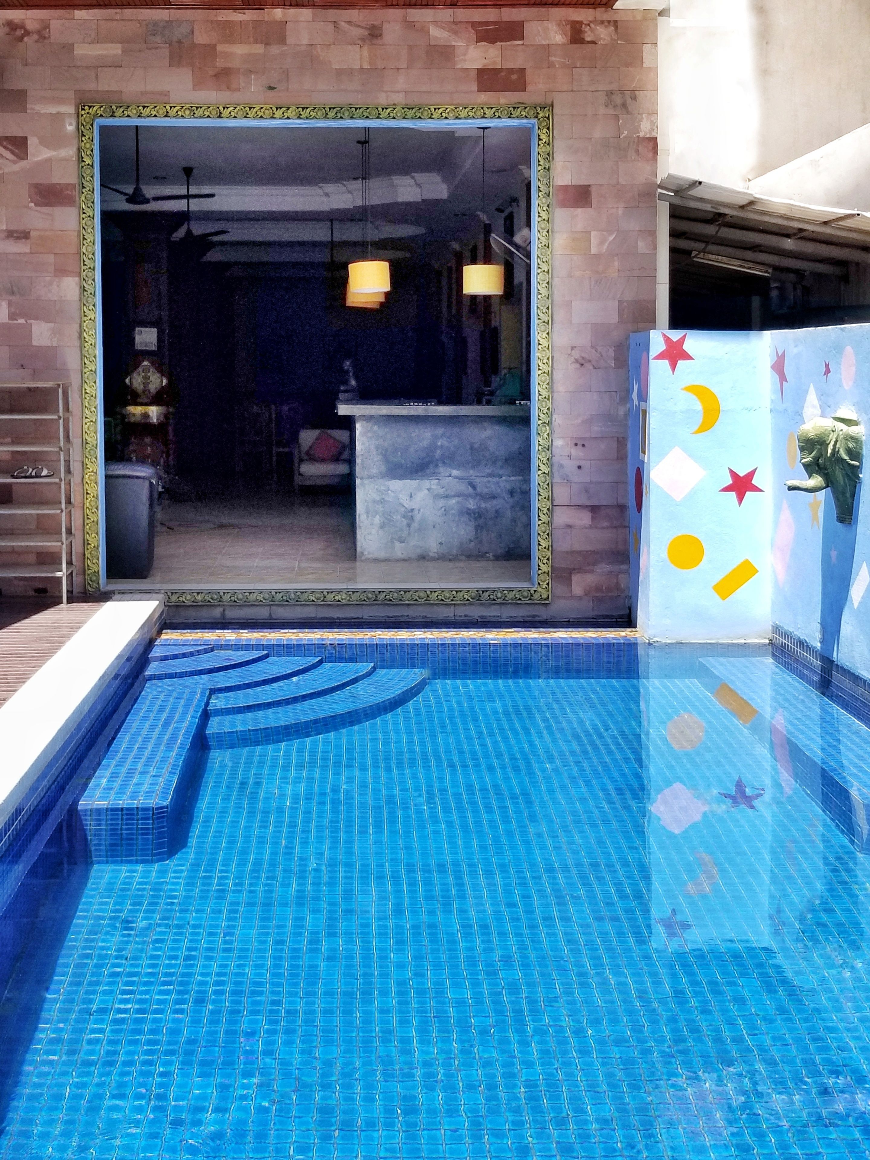 Une piscine aux carreaux bleus et dotée d’une bordure décorative.
