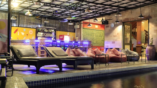 A pool area with lounge chairs and a bar. - Heart Language Angkor Hotel - Hostel (Siem Reap)
