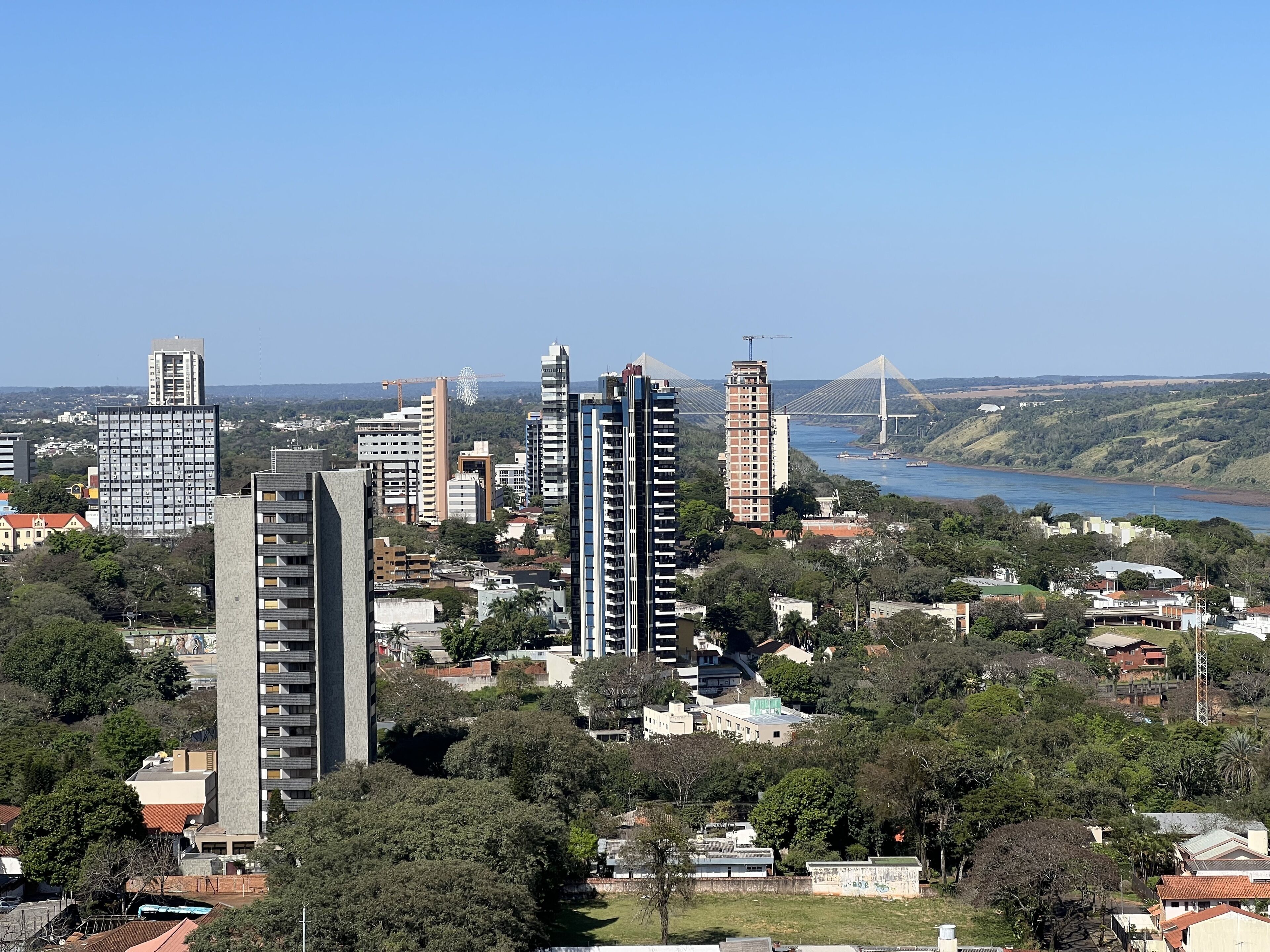 A cityscape with high-rise buildings, a river, and a bridge in the background.