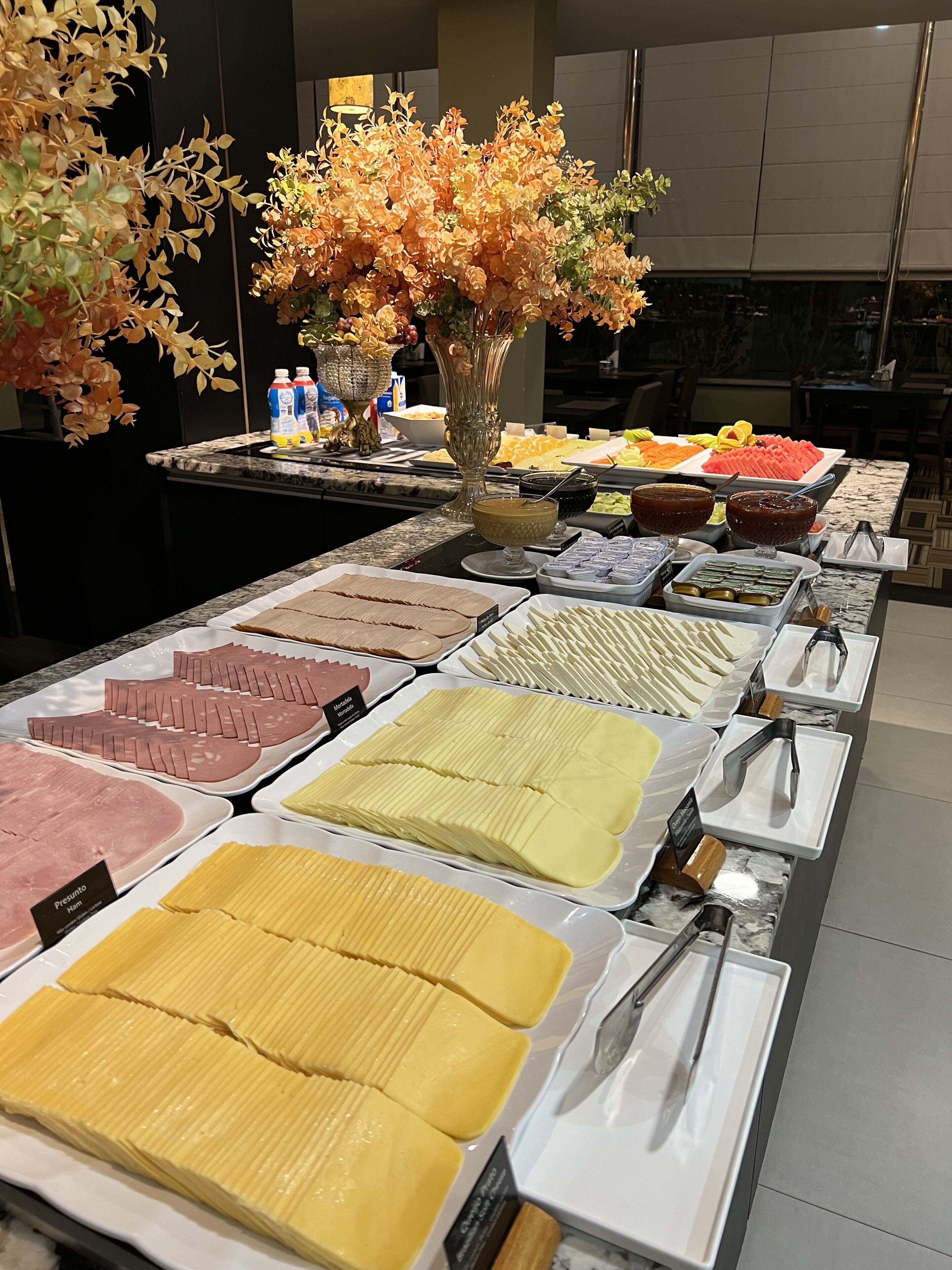 A buffet with various food items and a decorative centerpiece.